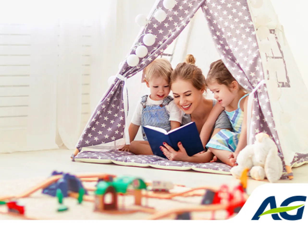 Moeder leest boek voor aan twee kinderen onder kindertent